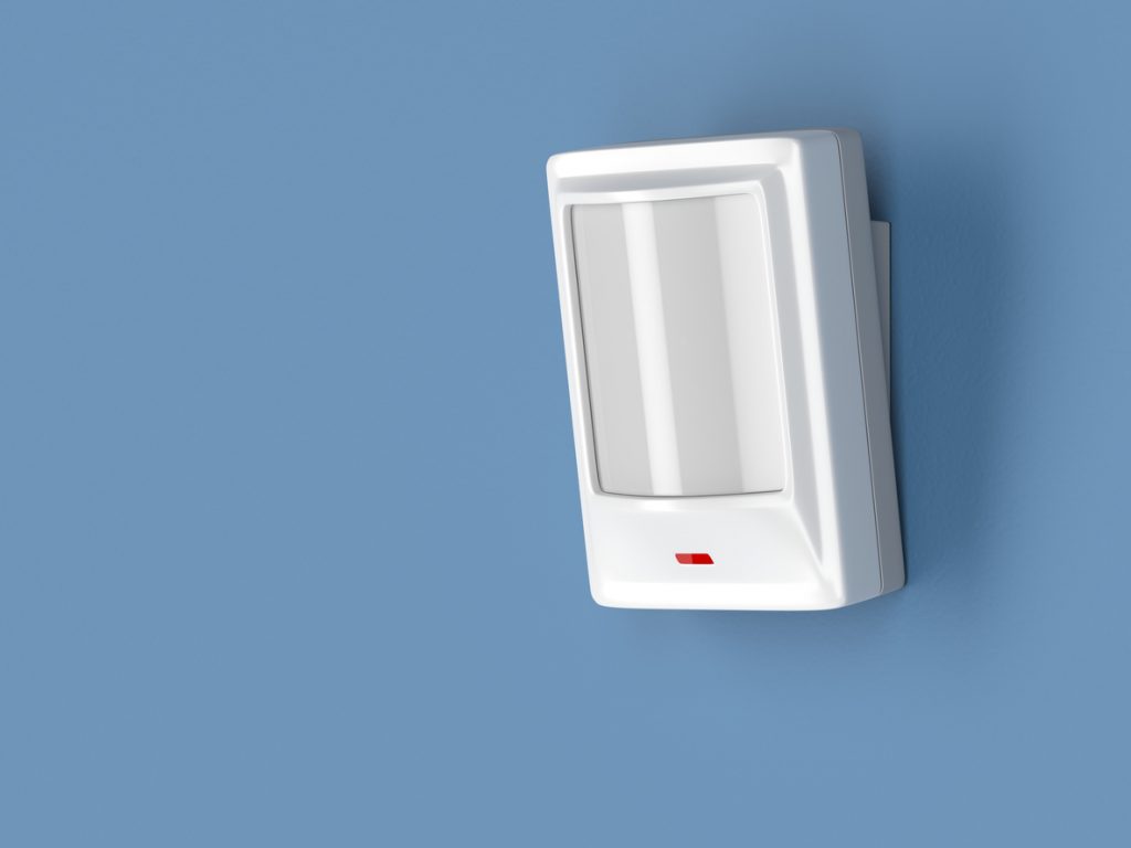 Motion sensor attached on a blue wall.