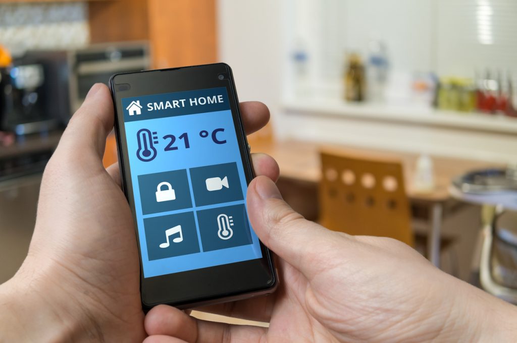 A man adjusting home temperature with a smartphone.