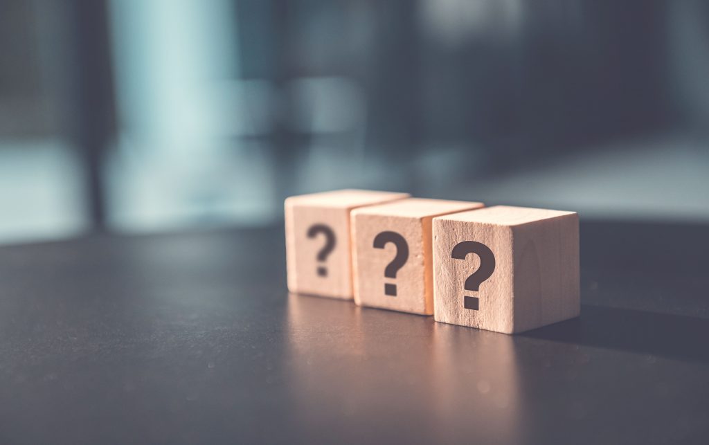 Blocks of question marks in wooden cubes displayed on a table.